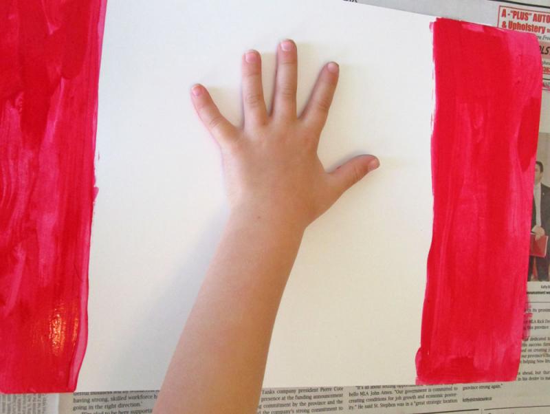 Place the hand on the paper - painted side down. 