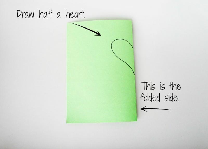 Draw half of a heart shape on the folded side of the paper.
