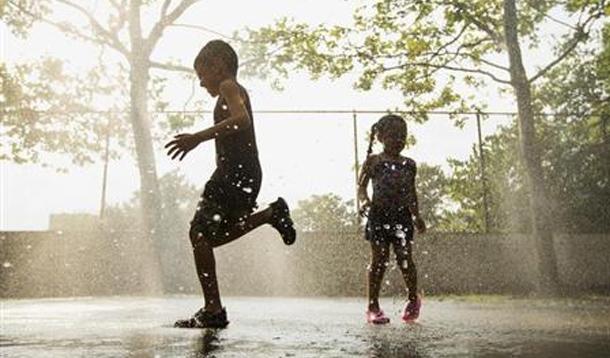 children playing in sprinkler