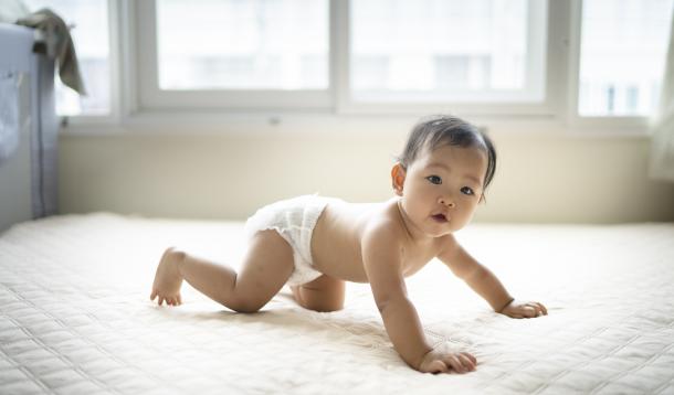Baby Crawling on white carpet with window in the background