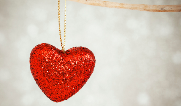 sparkly heart-shaped ornament in front of a white background