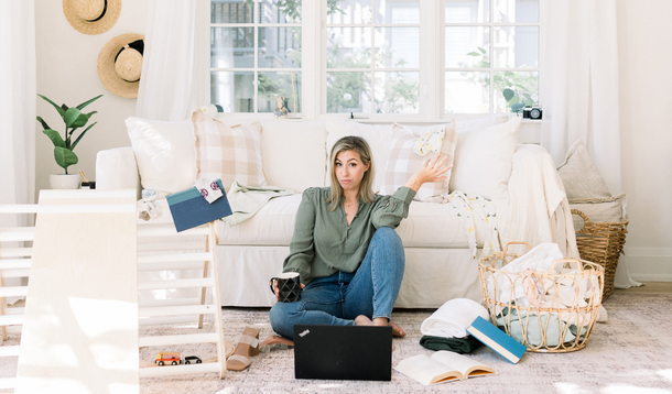 Woman sitting amidst a cluttered living room