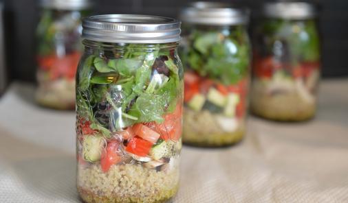 quinoa, vegetables, and greens in a jar