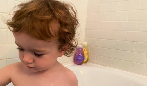 toddler playing in bathtub