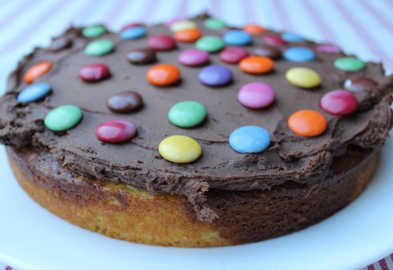This delicious swirled vanilla and chocolate layer cake with rich chocolate buttercream and smarties in the middle is a kid-friendly surprise! | YMCFood | YummyMummyClub.ca 